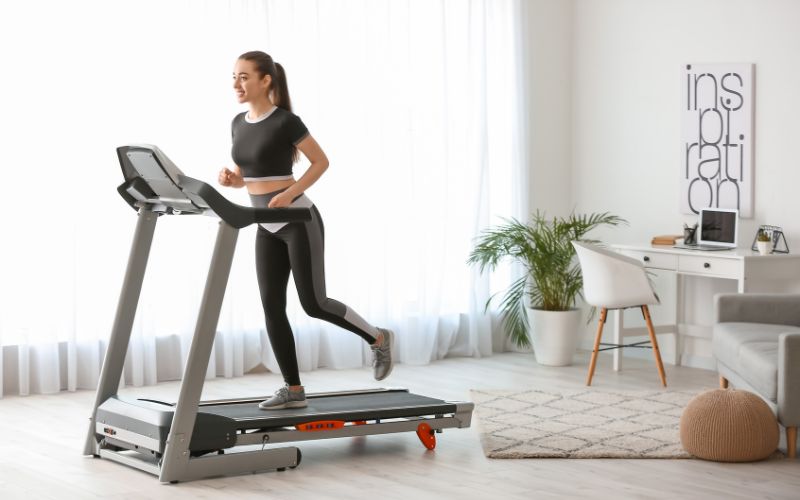 A lady running on a foldable treadmill at home